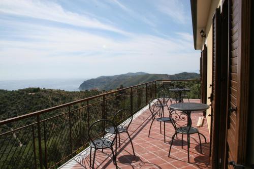 a balcony with chairs and tables and a view at Casale Florenzo in San Mauro Cilento