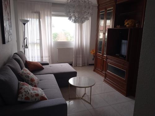 a living room with a couch and a tv at Mar de Gala in Suances