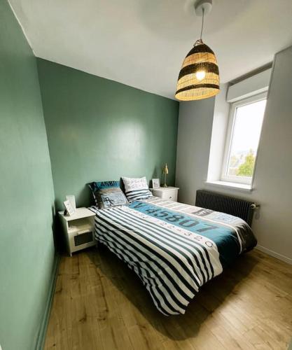 une chambre avec un lit et une grande fenêtre dans l'établissement Appartement l'effet Mers, à Mers-les-Bains