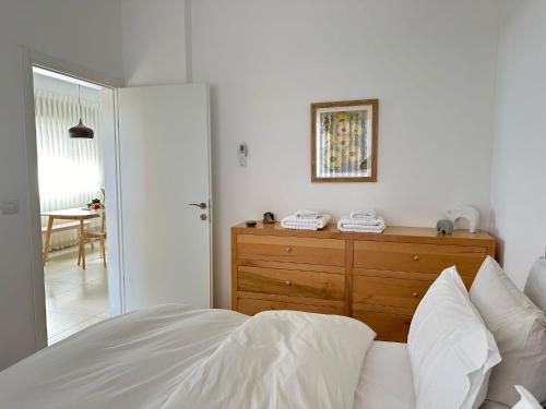 a bedroom with a bed and a dresser with a mirror at negevibe in Midreshet Ben Gurion