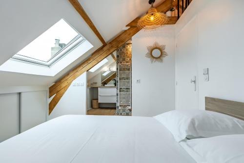 a bedroom with a white bed and a skylight at T2 cosy et chic près de la Défense et de Paris in Maisons-Laffitte