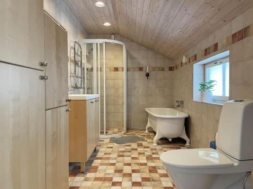 y baño con bañera, aseo y lavamanos. en Timrå Farmhouse en Timrå
