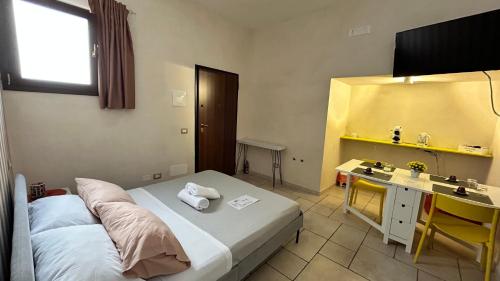 una camera d'albergo con letto, scrivania e lavandino di Standard Room a Pulsano