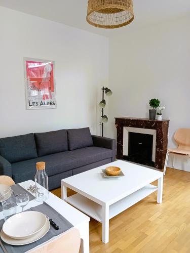 un salon avec un canapé et une table dans l'établissement 102 - Appart rénové avec grand salon et 1 chambre - Tram et Clinique Mutualiste à 1 min, à Grenoble