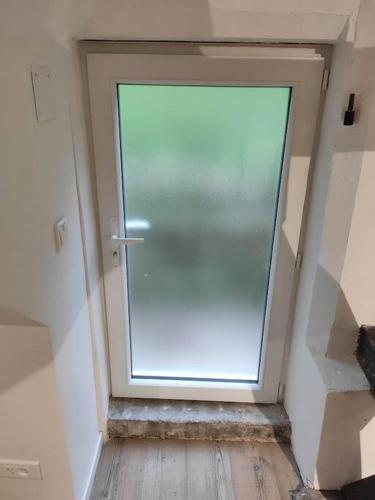 un couloir avec une porte en verre dans une chambre dans l'établissement Appartement - Vendôme, à Vendôme