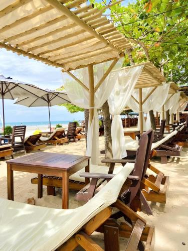 a group of chairs and tables and umbrellas on the beach at Pousada Capitão Thomaz in Jericoacoara