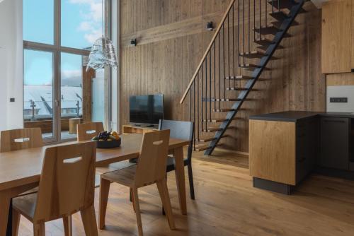 a kitchen and dining room with a wooden table and chairs at Aldrov Resort in Vítkovice