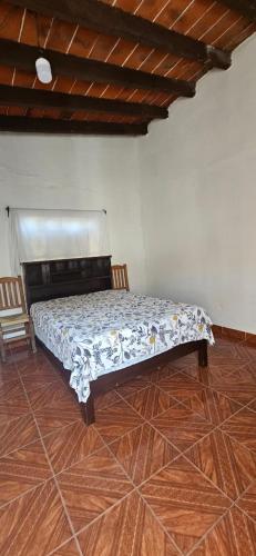 Cama en habitación con suelo de madera en Casa los Abuelos en Tepoztlán