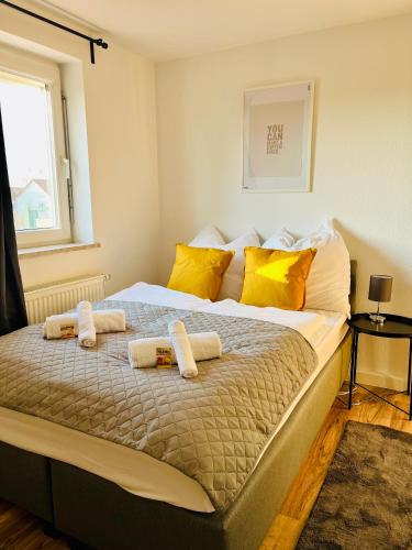 - une chambre avec un grand lit et des oreillers jaunes dans l'établissement Wohlfühl-Apartment Mareiki*Balkon*Stellplatz*WIFI*, à Erfurt