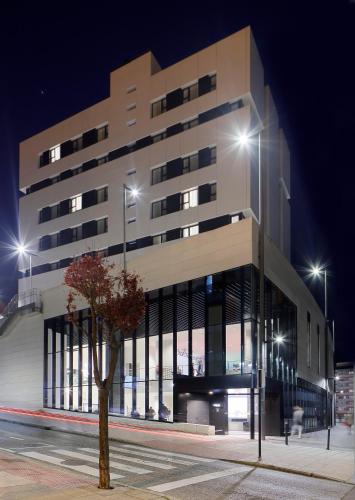 a building with a tree in front of it at Nuvō Hotel Boutique in Oviedo