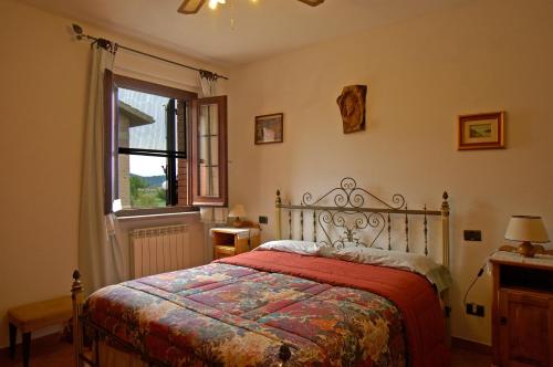 una camera da letto con un letto con un piumone rosso e una finestra di Agriturismo Val di Nappo a Castiglione della Pescaia