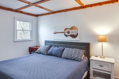 um quarto com uma cama azul e uma janela em Cozy Tennessee Cabin with Deck, Grill and Fireplace! em Smithville