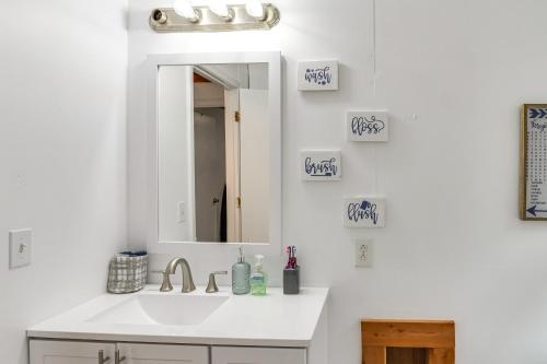 uma casa de banho branca com um lavatório e um espelho em Cozy Tennessee Cabin with Deck, Grill and Fireplace! em Smithville