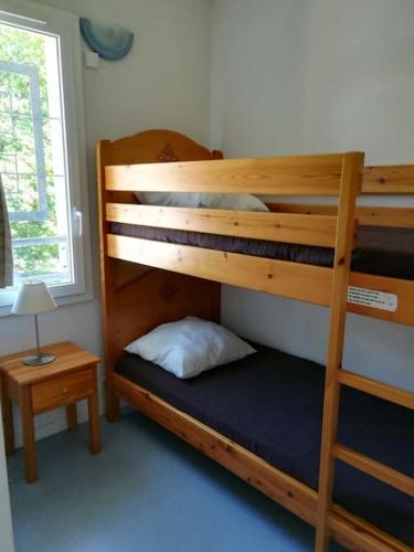 une chambre avec deux lits superposés et une table dans l'établissement Maison 3 chambres avec piscine proche plage, à Soulac-sur-Mer