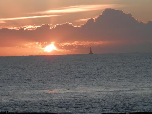 - un voilier dans l'océan avec un coucher de soleil dans l'établissement Les Fauvettes, à Royan