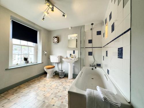 a bathroom with a tub and a toilet and a sink at The Old Locksmith Cottage, Ulverston - Lake District in Ulverston