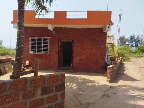 un edificio de ladrillo rojo con puerta y escalera en Swamiraj home stay en Ratnāgiri