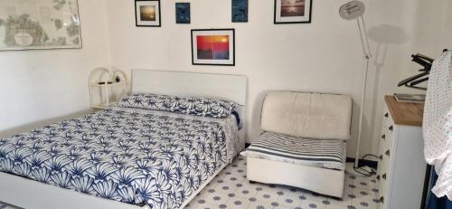 a bedroom with a bed and a chair at Monolocale a Rena Majore di Gallura in Rena Majore