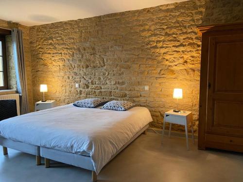 ein Schlafzimmer mit einem Bett und zwei Tischen mit Lampen in der Unterkunft Chambres d'Hôtes La Fraiseraie in Tellancourt