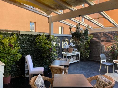 un giardino d'inverno con tavoli, sedie e piante di Les Chambres de Amelie B&B a Bologna