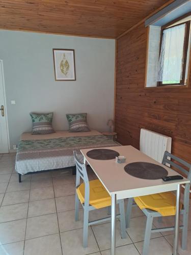 a room with a bed and a table and chairs at Gîte 4 "OLIA" aux Magnolias in Aubenas