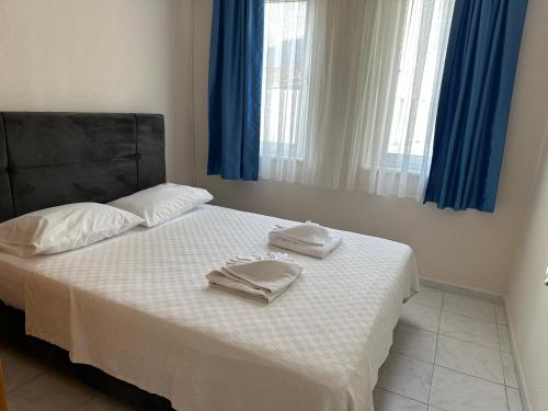 a bedroom with a bed with two towels on it at Stay Dalyan Apart Hotel in Ortaca