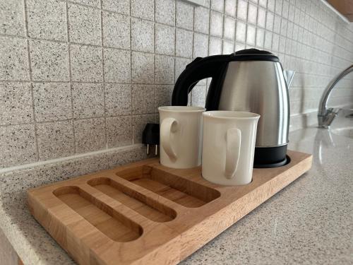 a wooden cutting board with two coffee cups on it at Stay Dalyan Apart Hotel in Ortaca