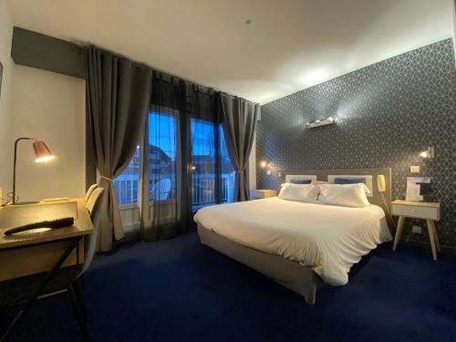 a hotel room with a large bed and a window at Savoie Hotel aux portes de Genève in Saint-Julien-en-Genevois
