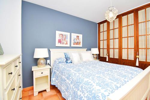 a bedroom with blue walls and a bed with a white bedspread at EXPOHOLIDAYS - Vistas al mar playa ensenada in Almerimar