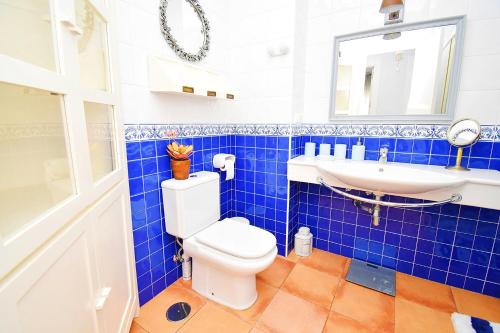 a blue tiled bathroom with a toilet and a sink at EXPOHOLIDAYS - Vistas al mar playa ensenada in Almerimar