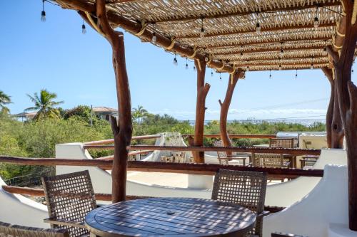 a table and chairs under a straw roof at Mantra Baja, Boutique Hotel in Los Barriles