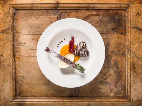 a white plate with food on a wooden table at Hotel Post in Prutz