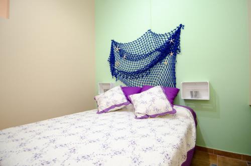 a bed with purple and white sheets and pillows at Mediterranean Terraces - Sandy Beach in Villajoyosa