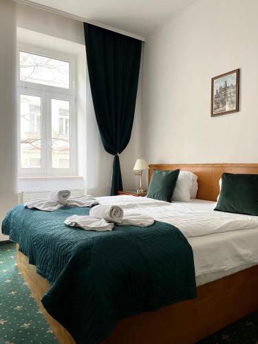 Dos camas en un dormitorio con toallas. en Hotel GEO en Praga