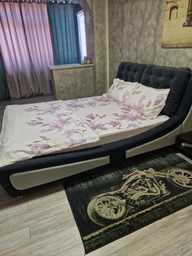 a bed in a room with a bed frame and a rug at Cornelius Studio in Galaţi