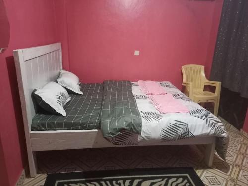 un letto in una camera da letto con parete rosa di Wamusa Homes at Chaka a Kiganjo