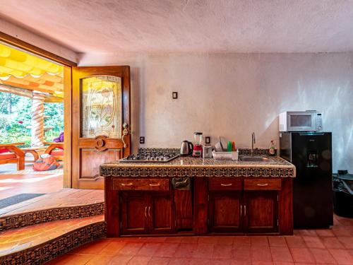 a kitchen with a sink and a stove top oven at Cabañas Elsa María, Cabañas para Hospedaje con Alberca y Jardín de Eventos in Atlautla