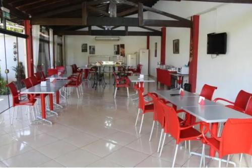 a dining room with tables and red chairs at HOTEL SANTA MARIA in Asunción