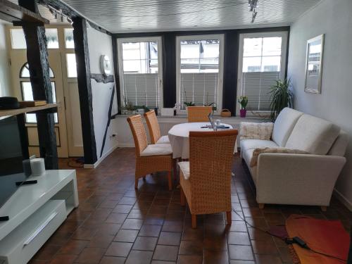 a living room with a couch and a table and chairs at Moderner Komfort trifft Historie in Hameln