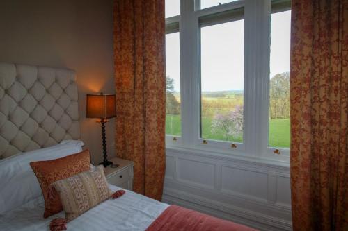 a bedroom with a bed and a large window at Geltsdale East Wing sleeps 6 with River Eden views near Carlisle & Ullswater in Wetheral