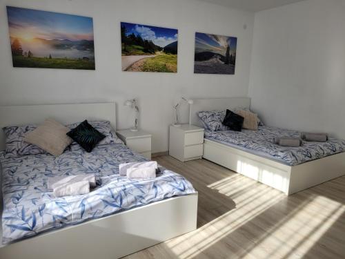 - une chambre avec 2 lits et des photos sur le mur dans l'établissement Apartament BESKIDLOVE, à Węgierska Górka