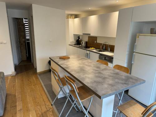 a kitchen with a counter and a refrigerator at Magnifique appartement rénové avec terrasse in Guyancourt