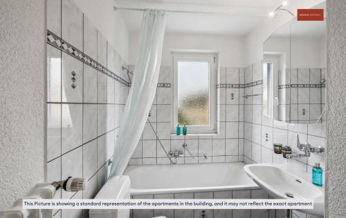 Baño blanco con bañera y lavamanos en Charming Apartment in Zurich, en Zúrich