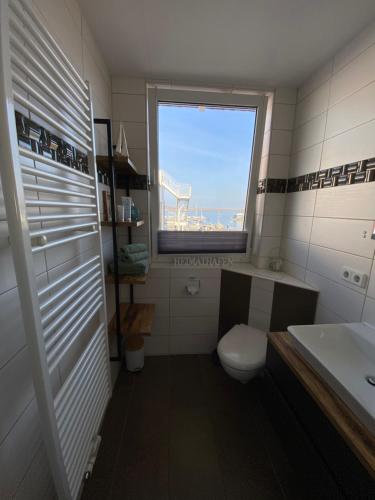 een badkamer met een toilet, een wastafel en een raam bij Ferienwohnung mit Sauna -Marina Mücheln Geiseltalsee in Mücheln