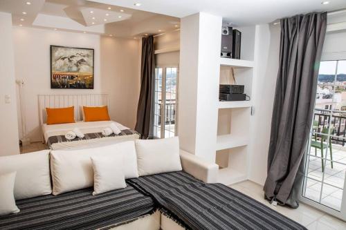 ein Wohnzimmer mit einem Sofa und einem Bett in der Unterkunft Seafront central Apt in Lavrio in Lávrio