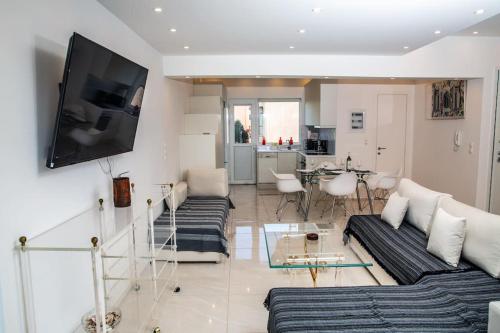 ein Wohnzimmer mit 2 Sofas und einem Flachbild-TV in der Unterkunft Seafront central Apt in Lavrio in Lávrio