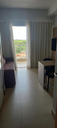 Cette chambre comprend un lit, une table et une fenêtre. dans l'établissement Lagoa Ecotawer, à Caldas Novas