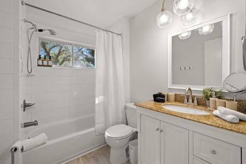 La salle de bains est pourvue de toilettes, d'un lavabo et d'une douche. dans l'établissement 5 mins to Honeymoon Island~Sand Volleyball~Firepit, à Palm Harbor
