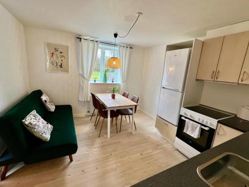 een woonkamer met een tafel en een keuken bij 5 minute walk to LEGO House - 50m2 apartment with garden / A unit in Billund
