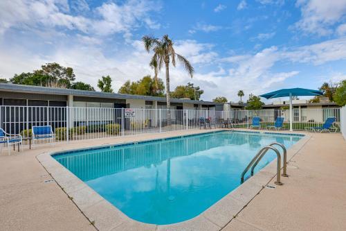a swimming pool with chairs and a palm tree at 1 Mi to Old Town! Snowbird Escape with Pool Access in Scottsdale